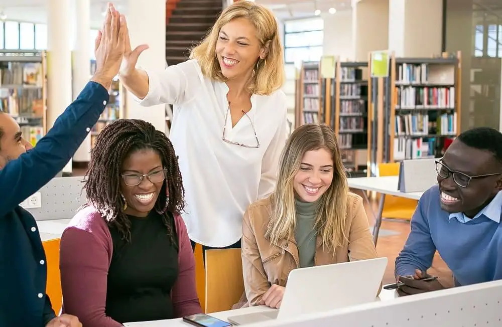 A group of students giving the teacher a high-five