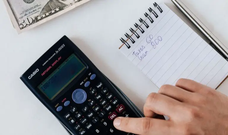 A person using a calculator and notepad for budgeting